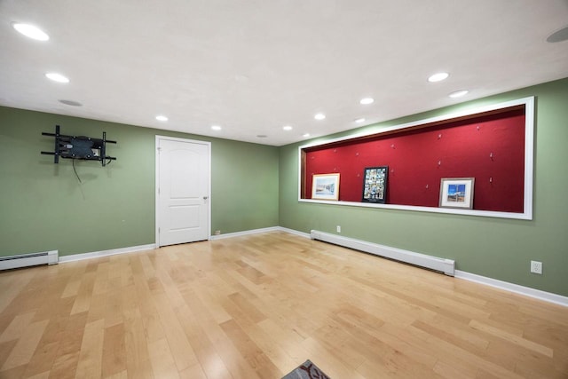 unfurnished room featuring hardwood / wood-style floors and baseboard heating