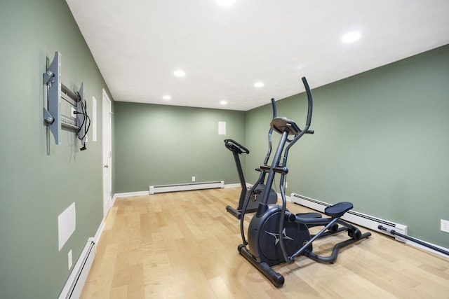 exercise room with light wood-type flooring and a baseboard radiator