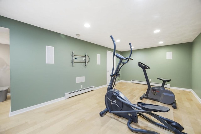 exercise room featuring light hardwood / wood-style flooring and a baseboard heating unit