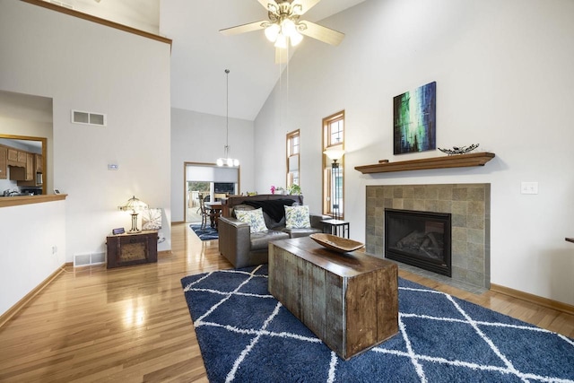 living room with hardwood / wood-style flooring, high vaulted ceiling, plenty of natural light, and ceiling fan