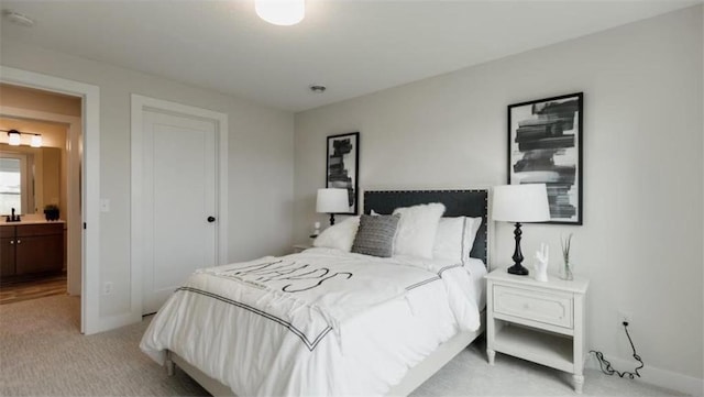 bedroom with light carpet and ensuite bathroom