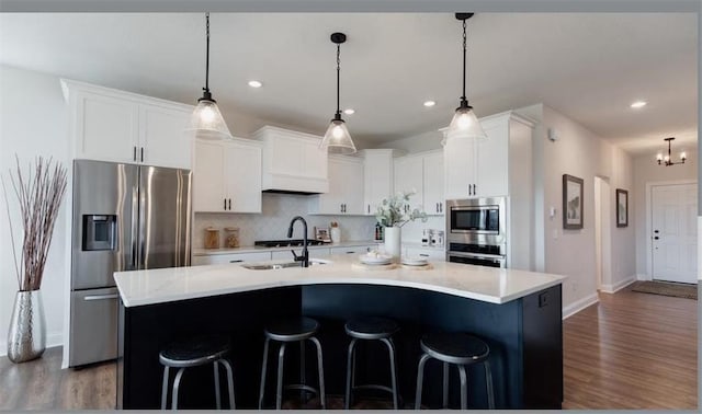 kitchen featuring a center island with sink, hanging light fixtures, and sink