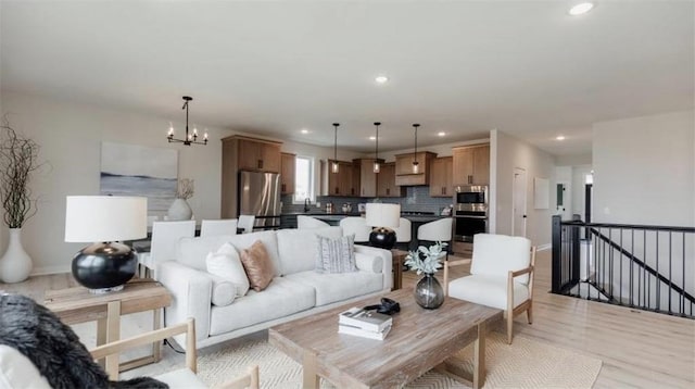 living room with light hardwood / wood-style floors and a notable chandelier