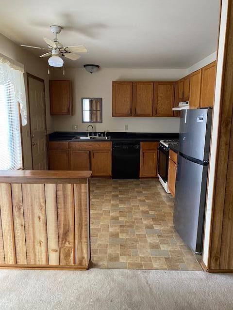 kitchen featuring light carpet, white range, sink, black dishwasher, and stainless steel refrigerator