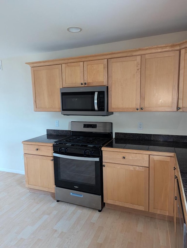 kitchen with light hardwood / wood-style floors, light brown cabinets, and appliances with stainless steel finishes