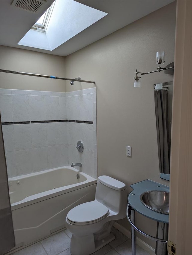 bathroom featuring tile patterned flooring, toilet, bathing tub / shower combination, and a skylight