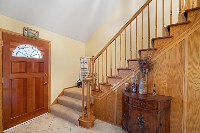 entryway with light tile patterned flooring and lofted ceiling