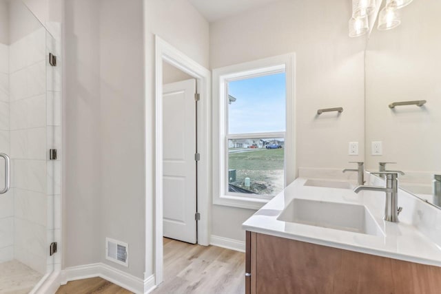 bathroom featuring hardwood / wood-style floors, vanity, and walk in shower