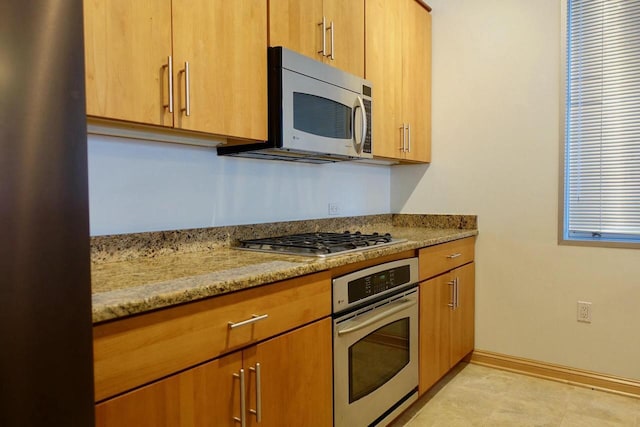 kitchen with light stone countertops and stainless steel appliances