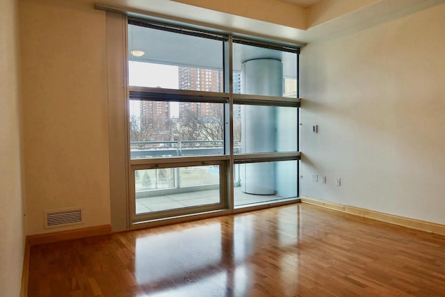 unfurnished room with hardwood / wood-style flooring