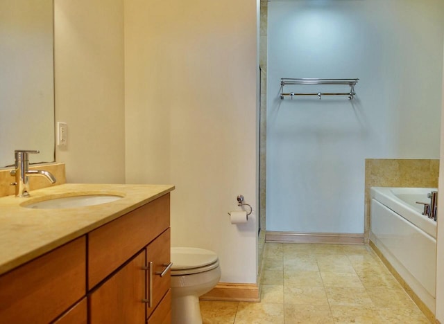 bathroom featuring a washtub, vanity, and toilet