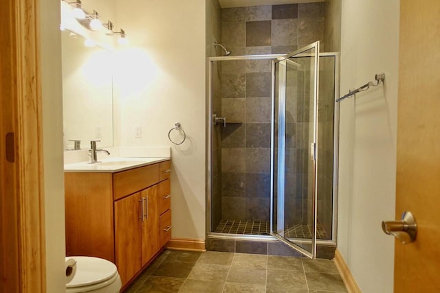 bathroom featuring vanity, toilet, and a shower with shower door