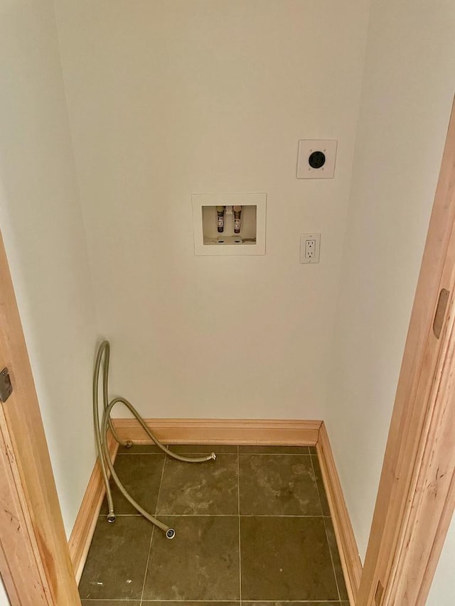 laundry area with hookup for an electric dryer, hookup for a washing machine, and dark tile patterned flooring