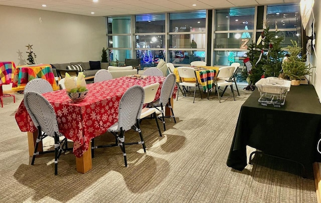 dining area with carpet flooring and a wall of windows