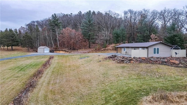 view of yard featuring a garage and an outbuilding