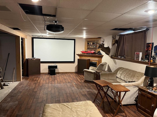 home theater room featuring a paneled ceiling and dark hardwood / wood-style flooring