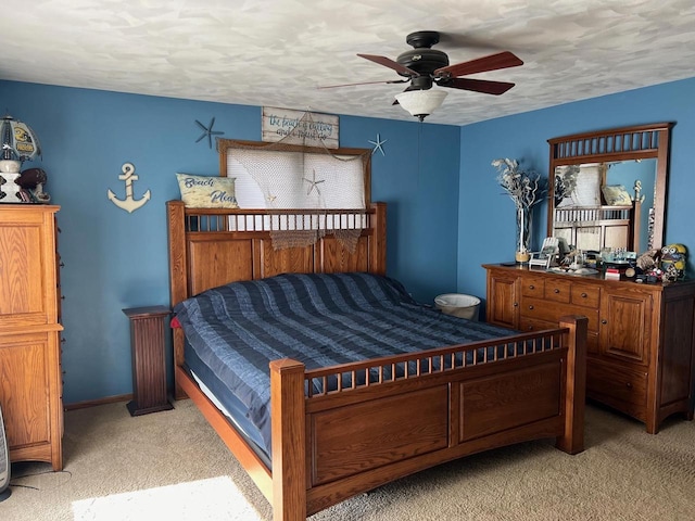 carpeted bedroom featuring ceiling fan and a textured ceiling