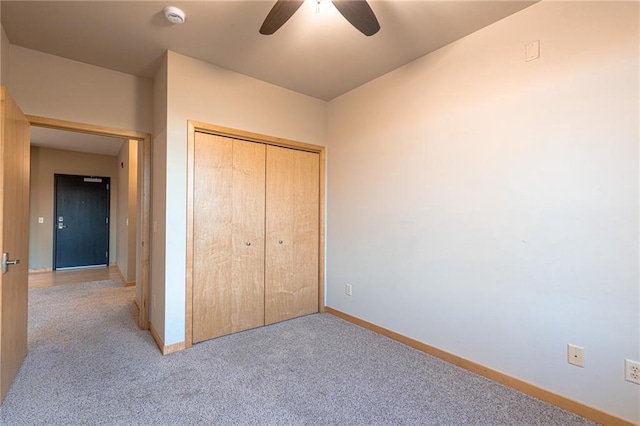 unfurnished bedroom featuring ceiling fan, a closet, and light carpet