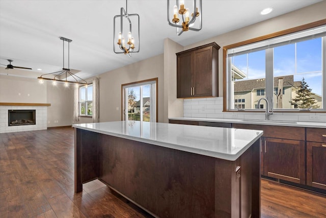 5550 N Amethyst Dr, Appleton, WI 54913 - kitchen with dark hardwood / wood-style floors, a fireplace, sink, and hanging light fixtures