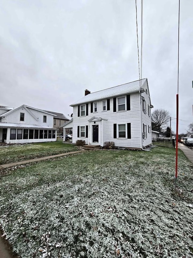 view of front of house with a sunroom and a front yard