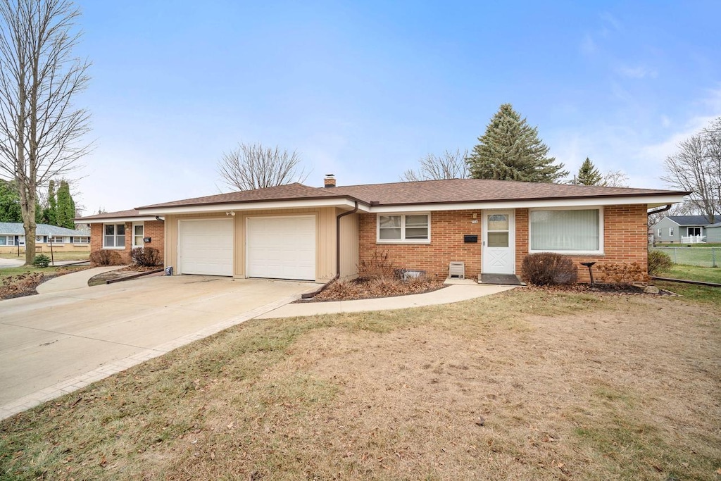 single story home featuring a front lawn and a garage