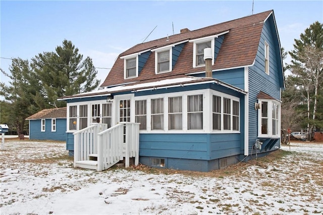 view of snow covered rear of property