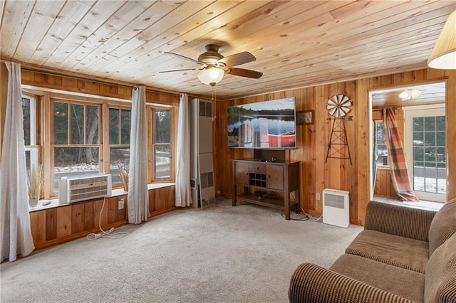 living room with a wealth of natural light, wooden walls, and light carpet