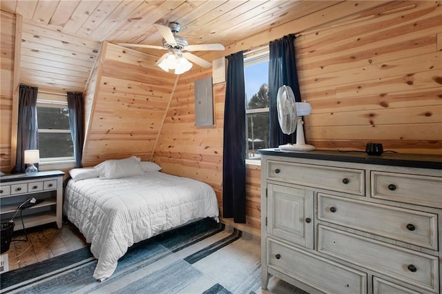 bedroom featuring ceiling fan, wooden walls, wooden ceiling, light hardwood / wood-style floors, and lofted ceiling