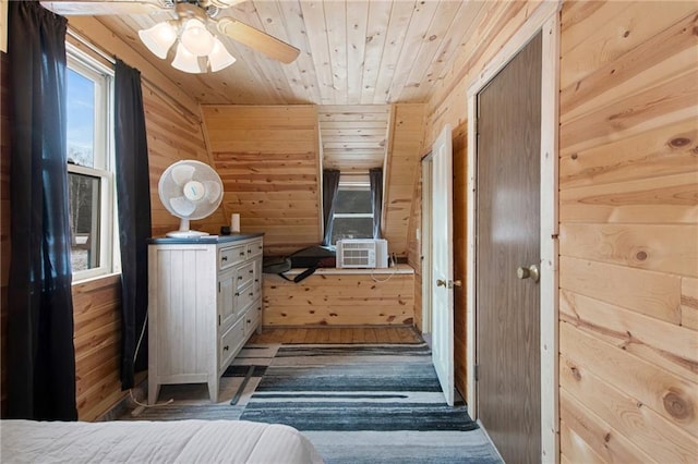 bedroom with cooling unit, wood walls, ceiling fan, and dark hardwood / wood-style floors