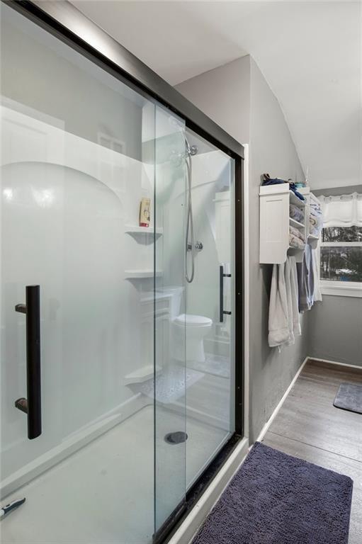 bathroom with hardwood / wood-style flooring and a shower with door