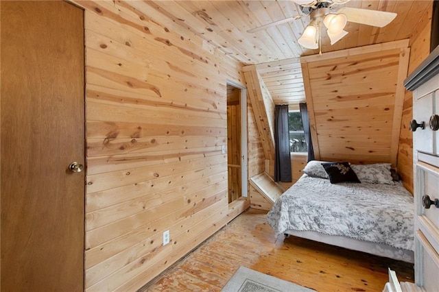 bedroom featuring ceiling fan, wood walls, wooden ceiling, and light hardwood / wood-style flooring