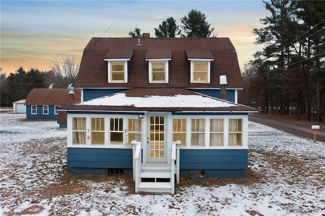 view of snow covered back of property