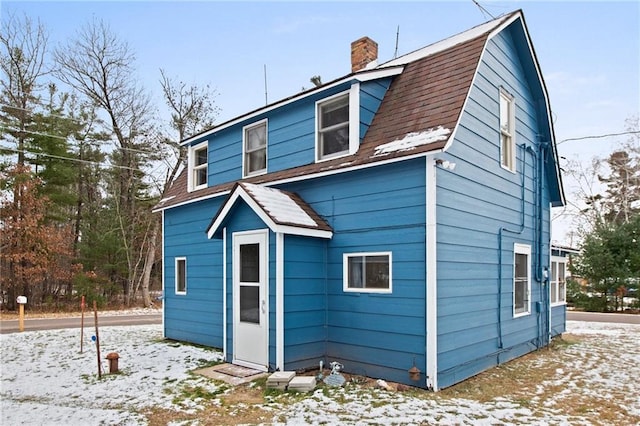 view of snow covered rear of property