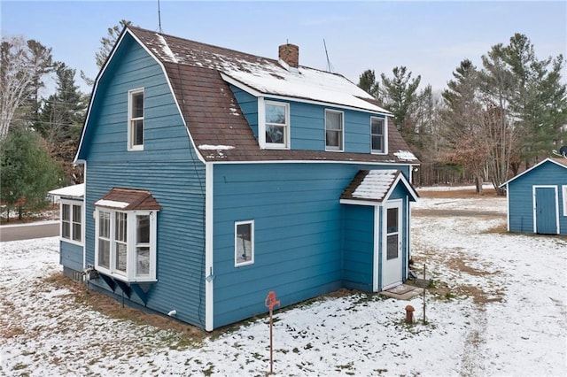 view of snowy exterior featuring a storage shed