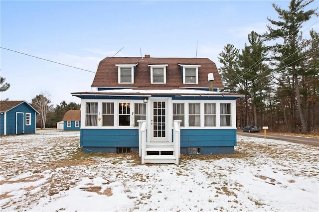 snow covered house with a sunroom