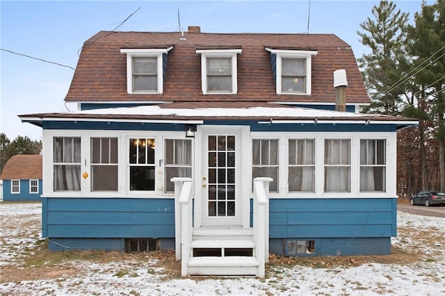 view of snow covered rear of property