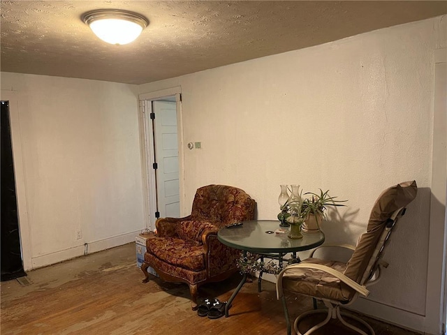 sitting room with a textured ceiling and hardwood / wood-style flooring