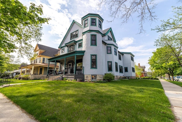 view of front of property featuring covered porch and a front yard