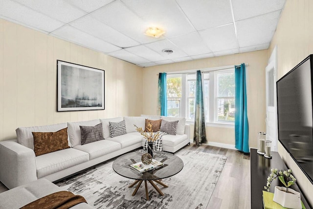 living room featuring a paneled ceiling and hardwood / wood-style floors