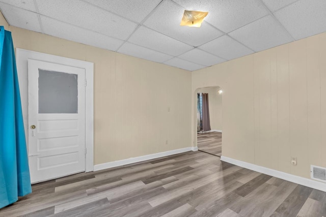 spare room with a drop ceiling and light wood-type flooring