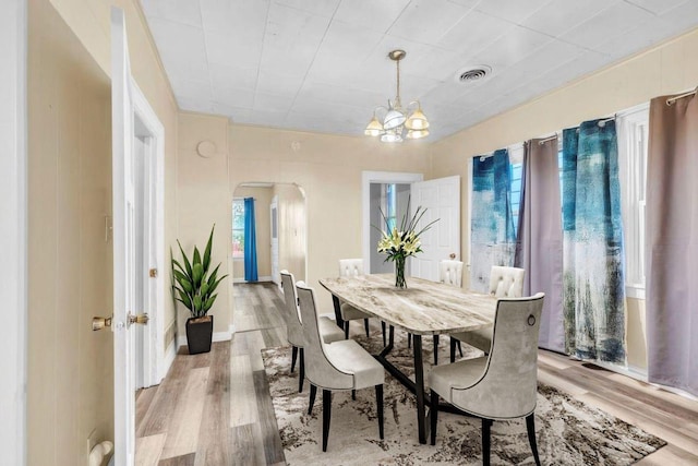 dining space featuring light hardwood / wood-style floors and a notable chandelier