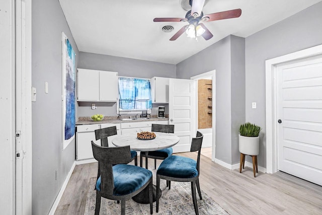 dining room featuring ceiling fan, sink, and light hardwood / wood-style floors