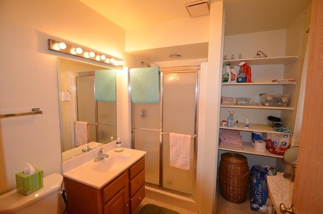 bathroom with tile patterned floors, vanity, toilet, and walk in shower