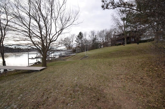 view of yard featuring a water view and a dock