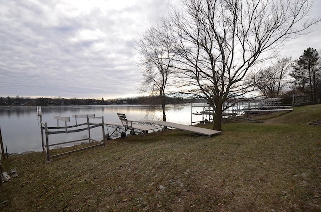 dock area featuring a lawn and a water view