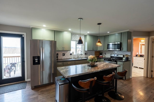 kitchen with dark hardwood / wood-style floors, sink, stainless steel appliances, and dark stone counters