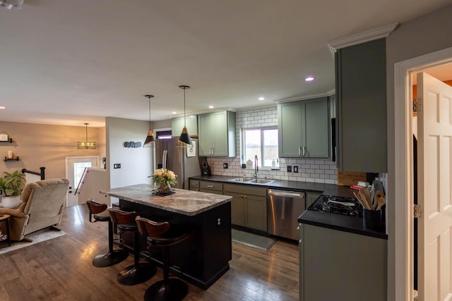 kitchen featuring dark hardwood / wood-style flooring, stainless steel appliances, a kitchen island, and sink