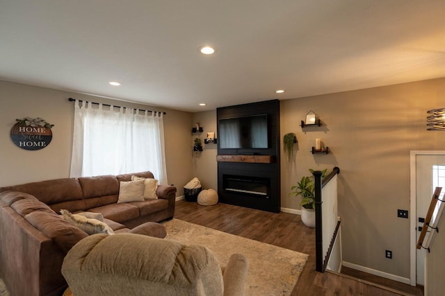 living room with dark hardwood / wood-style flooring and a large fireplace