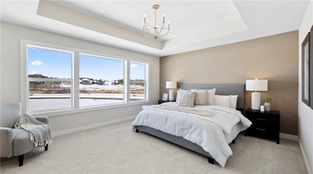 bedroom with carpet floors, an inviting chandelier, baseboards, and a raised ceiling