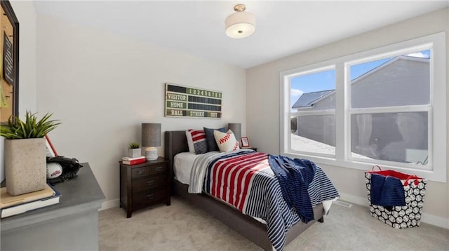 bedroom featuring baseboards and light colored carpet